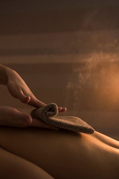 Main de l'esthéticienne massant le dos de la femme avec une serviette chaude au spa | Photo Gratuite